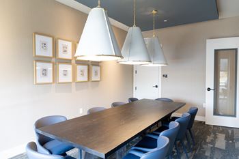 A conference room with a long table and blue chairs.